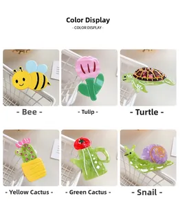 Detail shots of colorful acrylic cartoon bee, turtle, and cactus hair clips in white baskets