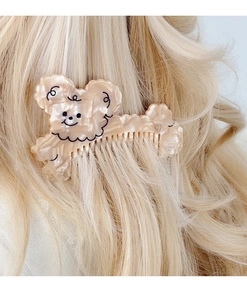 Detail of cute beige cartoon bear cellulose acetate hair comb on blonde hair