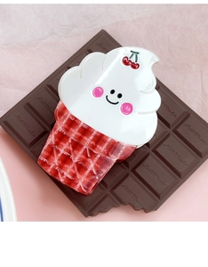 Close-up of a cute ice cream claw clip with a cherry accent on a pink background