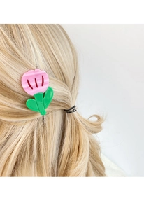 Detail of pink tulip hair clip with green leaves in acetate on blonde hair