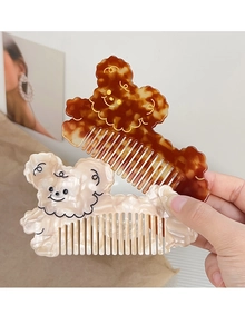 Close-up of tortoise shell and ivory acetate bear-shaped hair combs with cute facial details