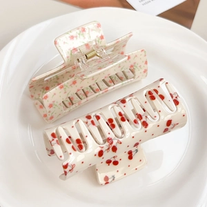 Haarklemmen set in crème met bloemen- en kersendesign op een elegant wit keramisch bord
