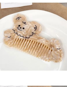 Close-up of a cute dog-shaped acetate hair comb with a creamy marble texture