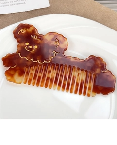 Detail of bear-shaped acetate hair comb with tortoise pattern and gold accents