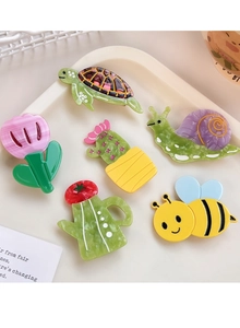 Detailed view of colorful acetate cartoon hair clips featuring turtle and bee designs