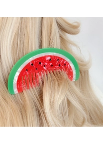 Detailed close-up of a watermelon acetate hair comb styled in wavy blonde hair for hair styling