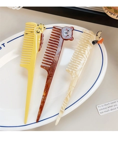 Close-up of three cartoon animal long-handle combs with giraffe bear and duck patterns