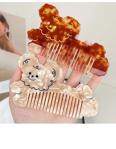 Detail of bear-shaped acetate hair combs in amber tortoiseshell and pearly white finishes
