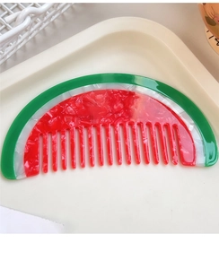 Detailed macro view of the watermelon slice hair comb with marbled acetate texture