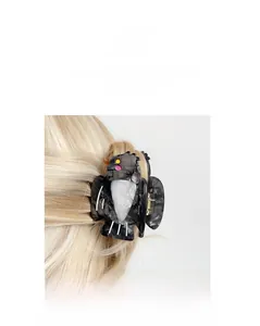 Detail of owl hair claw clip in marble grey acetate with golden spring mechanism