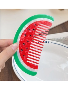Detailed view of watermelon shaped acetate hair comb with red green resin layers