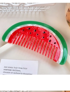 Close-up of watermelon-shaped acetate hair comb with vibrant red and green colors