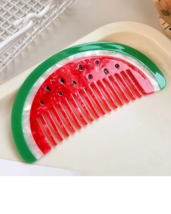 Detail of watermelon-shaped acetate hair comb with realistic red and green color patterns