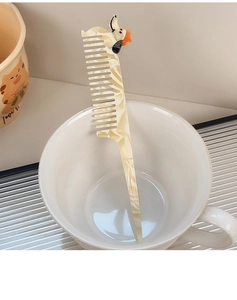 Close-up of cream marble pattern hair comb with a cute dachshund dog shaped top handle