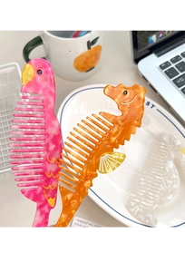 Detail of pink parrot and orange seahorse acetate hair combs on a clean desk
