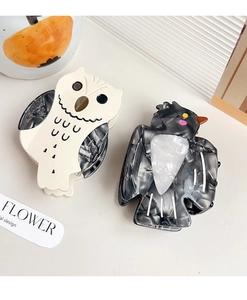 Close-up of owl and bird hair claws made of acetate with marble textures and cute details