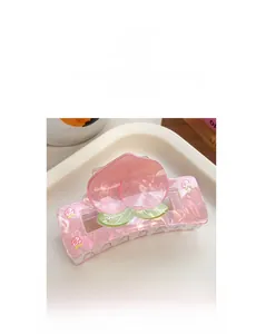 Detail showing a sweet peach hair claw clip with pink translucent finish and 3D fruit decor