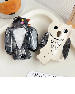 Detail view of owl and crow hair claws made of premium marble pattern acetate material