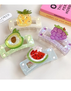 Detail of fruit claw clips showing pineapple, avocado, grape, and watermelon motifs