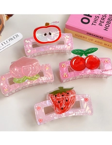 Detail of four fruit-themed hair claws with pearlescent finish and printed patterns
