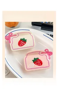 Détail de pinces à cheveux en acétate motif gâteau fraise avec nœud rose et design toast