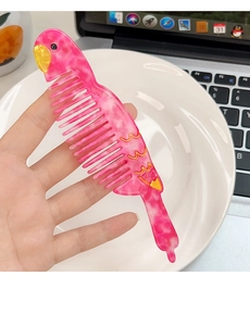 Detail showing hand-held pink marble acetate hair comb in creative parrot shape