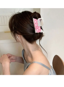 Detailansicht der Haarspange mit Blumen-Hundemotiv im Haar einer Frau