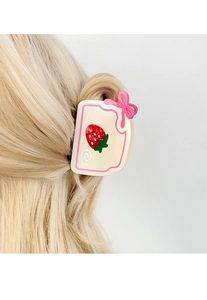Gros plan d'une pince à cheveux gâteau fraise en acétate avec un nœud rose