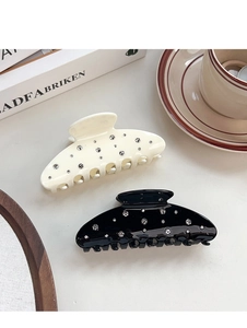 Close-up of black and cream hair claws with sparkling rhinestones in a lifestyle setting