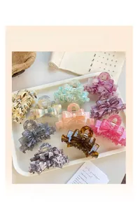 Selection of acetate bow hair clips in marble and tortoiseshell patterns on a tray