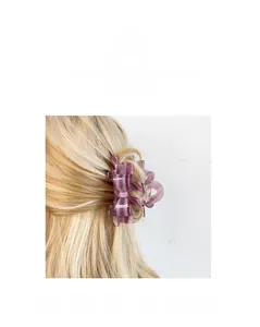 Detailed close-up of a purple acetate bow hair claw clip styled on blonde hair