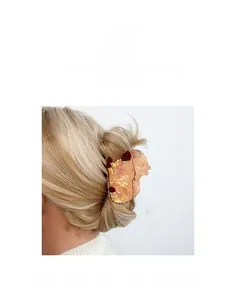 Detail of pink pearlescent corgi hair claw clip worn on blonde hair for styling
