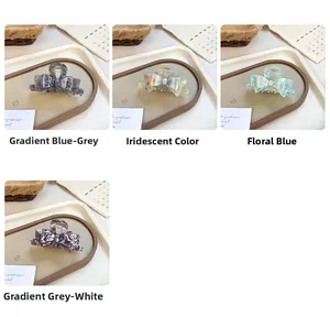Detailed views of acetate bow hair claws in four elegant patterns with marble textures