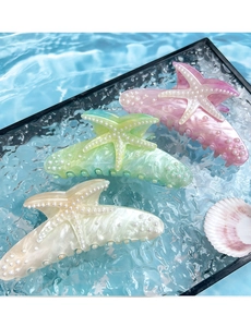 Close-up of starfish hair claws with marble texture and pearl embellishments