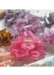 Macro detail of elegant acetate bow hair claw clips with marble textures in various colors