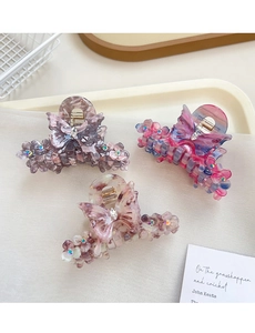Détail de pinces à cheveux papillon avec strass colorés et accents floraux