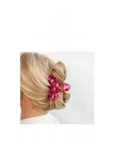 Pink acetate flower hair claw clip with rhinestones shown on a model's hair bun