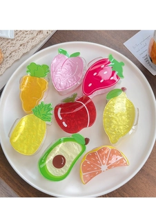 Close-up of assorted fruit-shaped hair claws including strawberry and peach designs