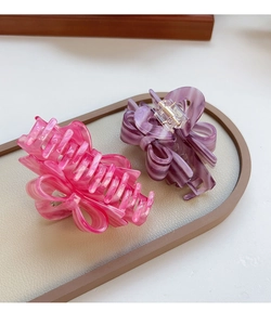 Macro shot of large acetate hair claws in fuchsia and violet with marble texture