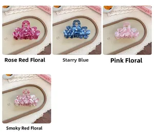 Detailed macro view showing four floral acetate hair claws with sparkling rhinestone centers