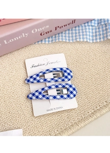 Detail of blue and white gingham fabric snap hair clips on jewelry display card