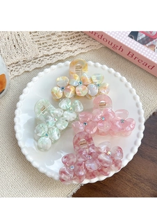 Detail of floral acetate hair claws with marble texture and rhinestones in four colors