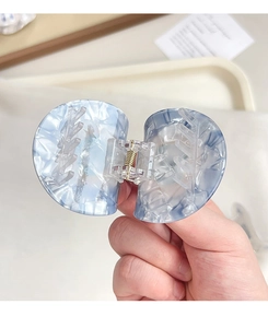 Détail de la pince à cheveux œil bleu avec texture marbrée semi-transparente élégante