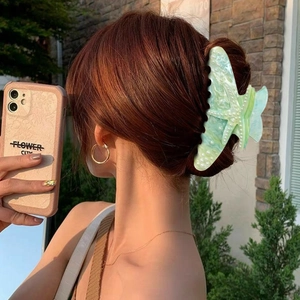 Starfish shaped acrylic claw clip in mint green with pearls worn on long hair