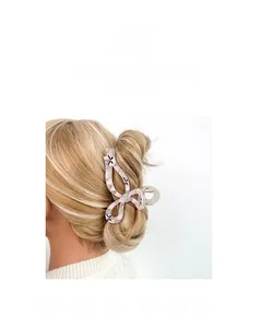 Dettaglio della molletta per capelli a scacchi rosa su capelli biondi che mostra la tenuta