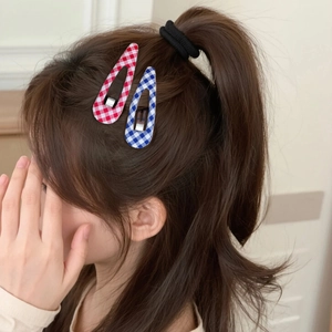Plaid fabric BB hair clips in blue and red shown on a model for a sweet trendy look
