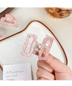 Detail of pink marble claw clip with sturdy gold spring for thick hair styling