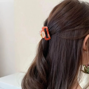 Vibrant orange apple hair claw clip shown on model for a sweet Korean summer hairstyle