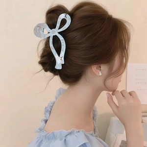 Pinza per capelli a fiocco 3D azzurro con finitura iridescente su modella donna
