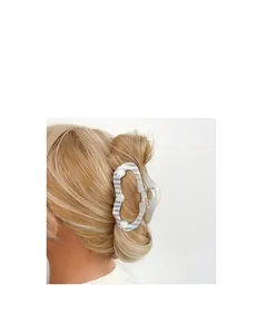 Gros plan d'une pince à cheveux à rayures bleues et marguerites dans un chignon élégant
